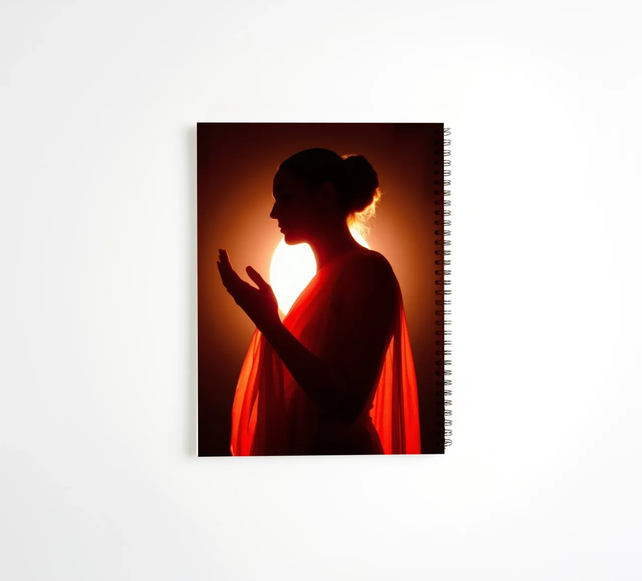 Elegant silhouet van een figuur omringd door warme gloed notitieboek met spiraal van DesignDoodle