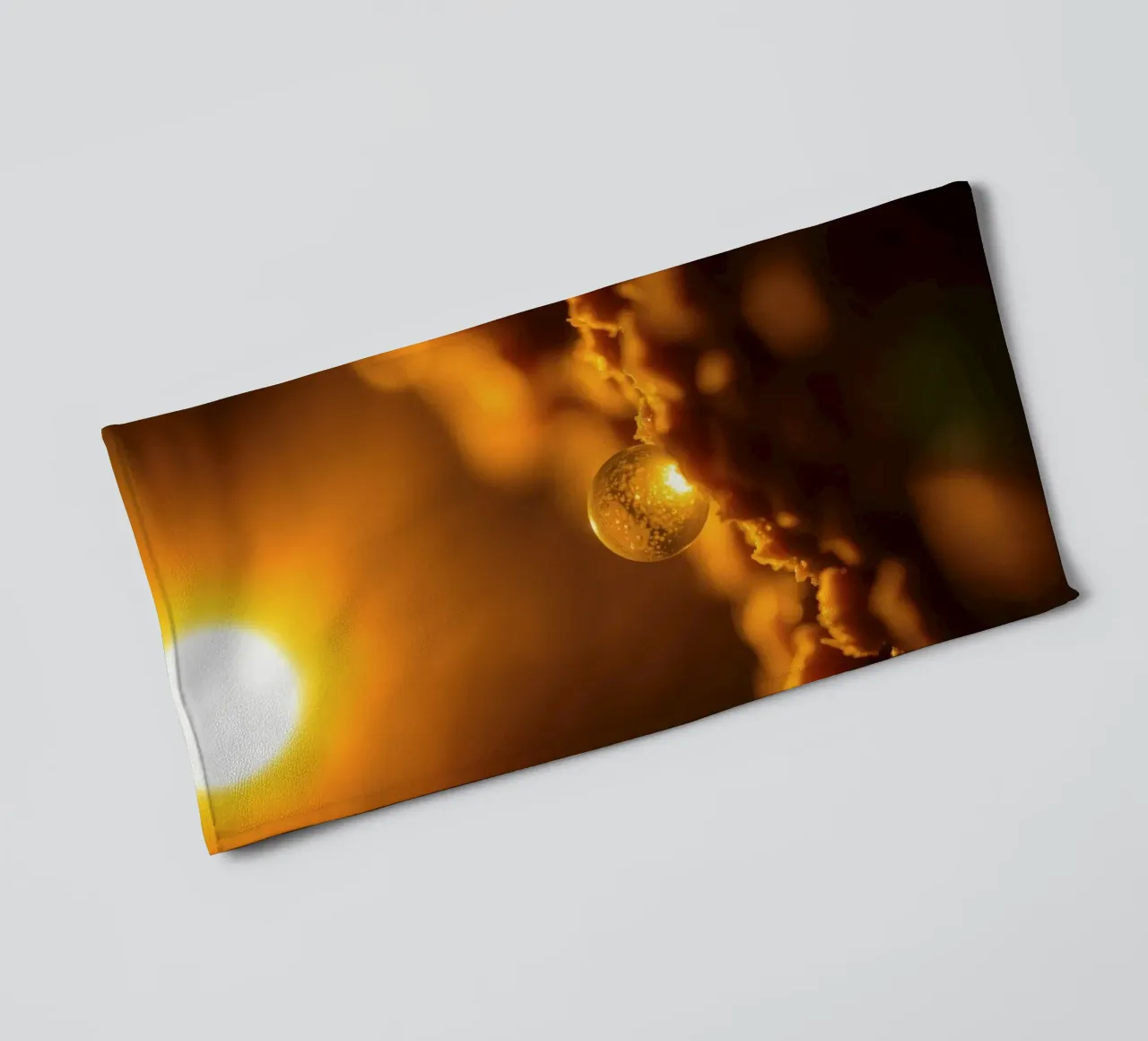 Orbe d'or transformateur reflétant la lumière sur une surface douce serviette de bain de DesignDoodle