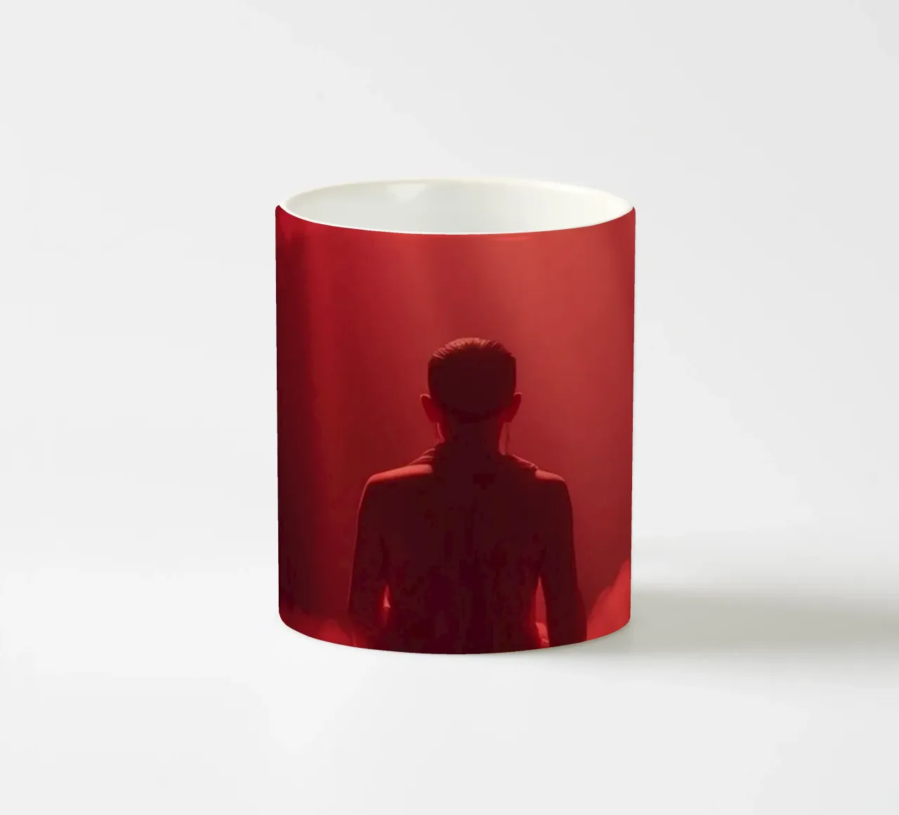 Captivating red light envelops a man sitting on a box in fog ceramic mug by DesignDoodle