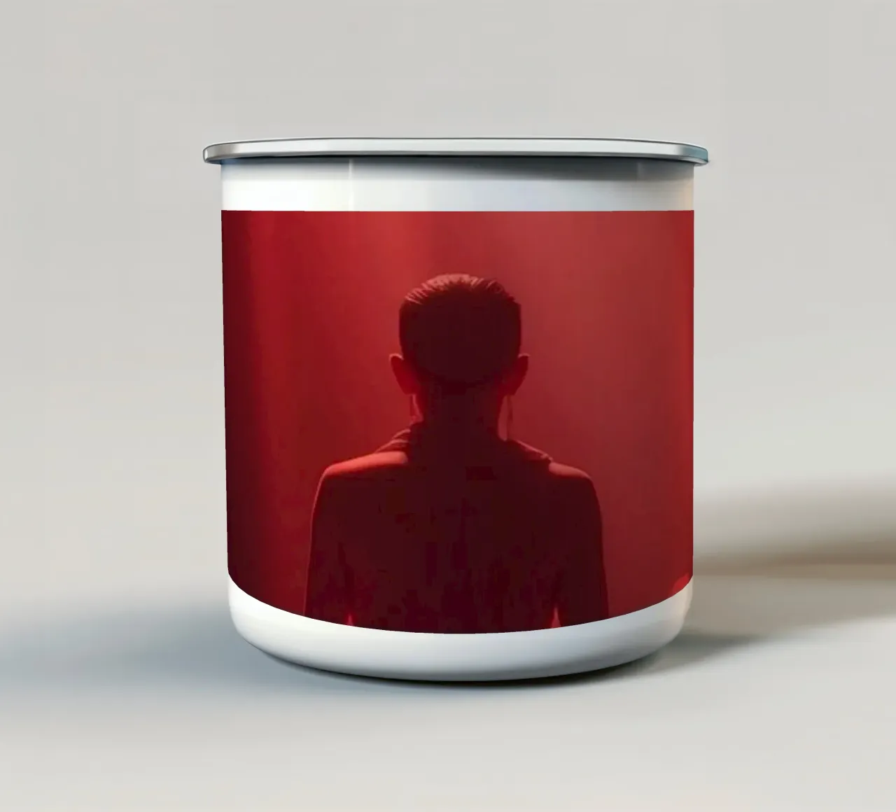 Captivating red light envelops a man sitting on a box in fog enamel mug by DesignDoodle