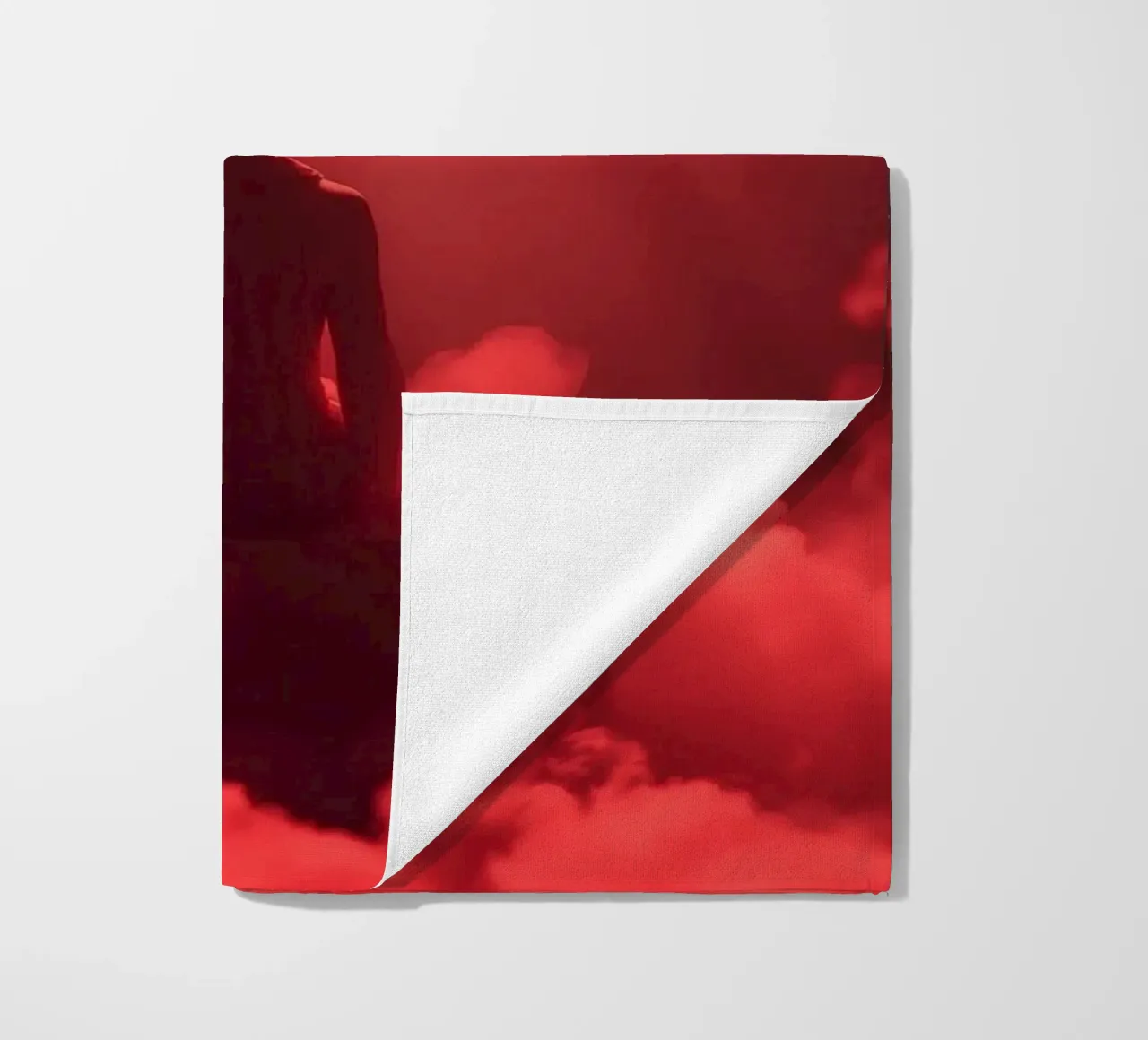 Captivating red light envelops a man sitting on a box in fog beach towel by DesignDoodle
