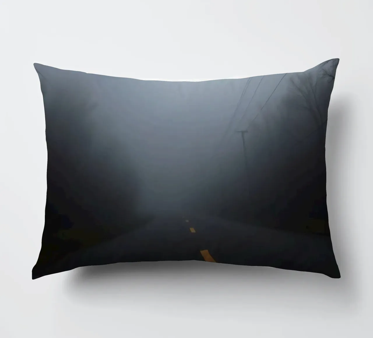 Strada nebbiosa con striscia gialla che scompare nella fitta nebbia cuscino da DesignDoodle