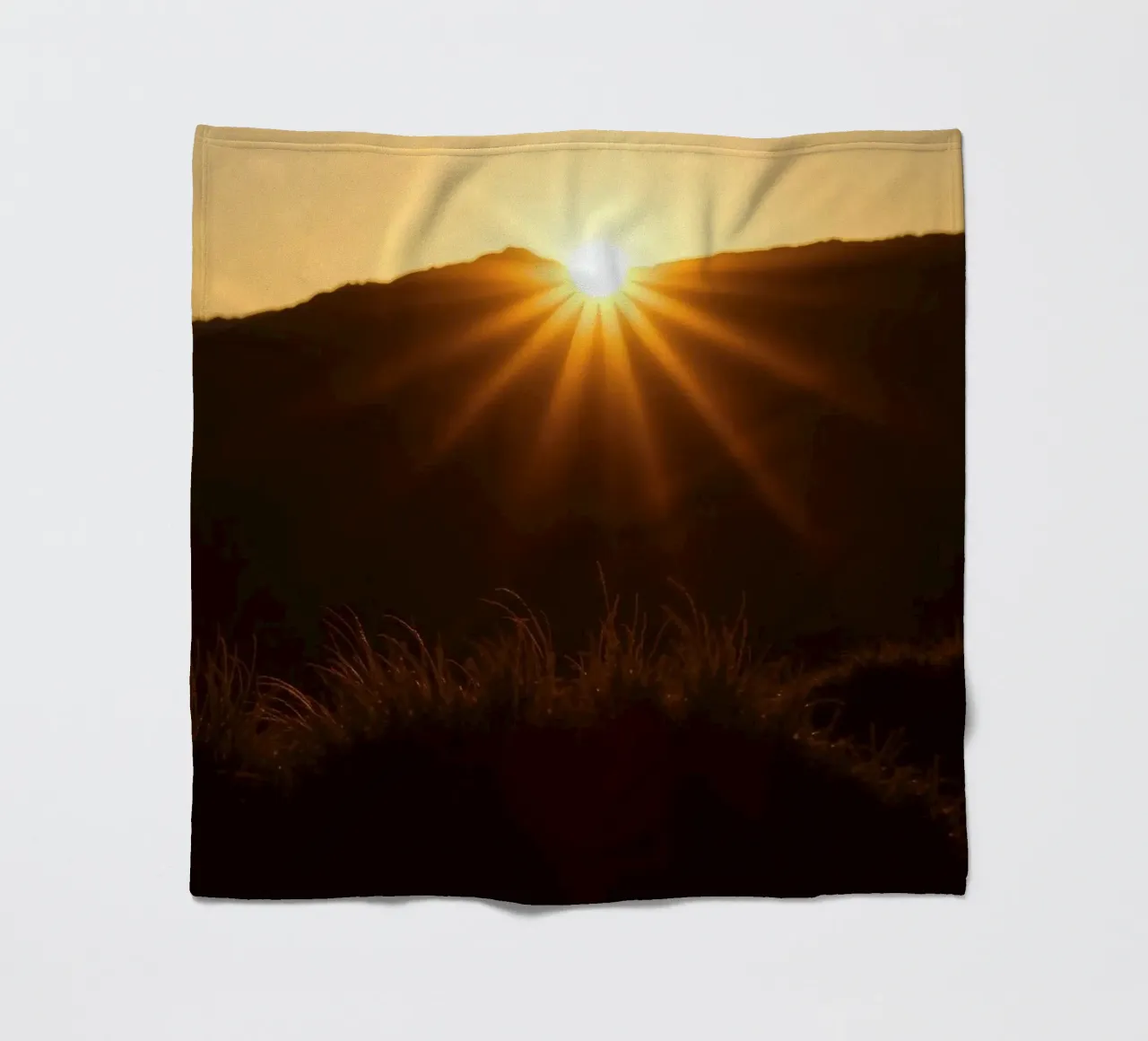 Vibrant sunset casting rays over hillside fleece blanket by DesignDoodle