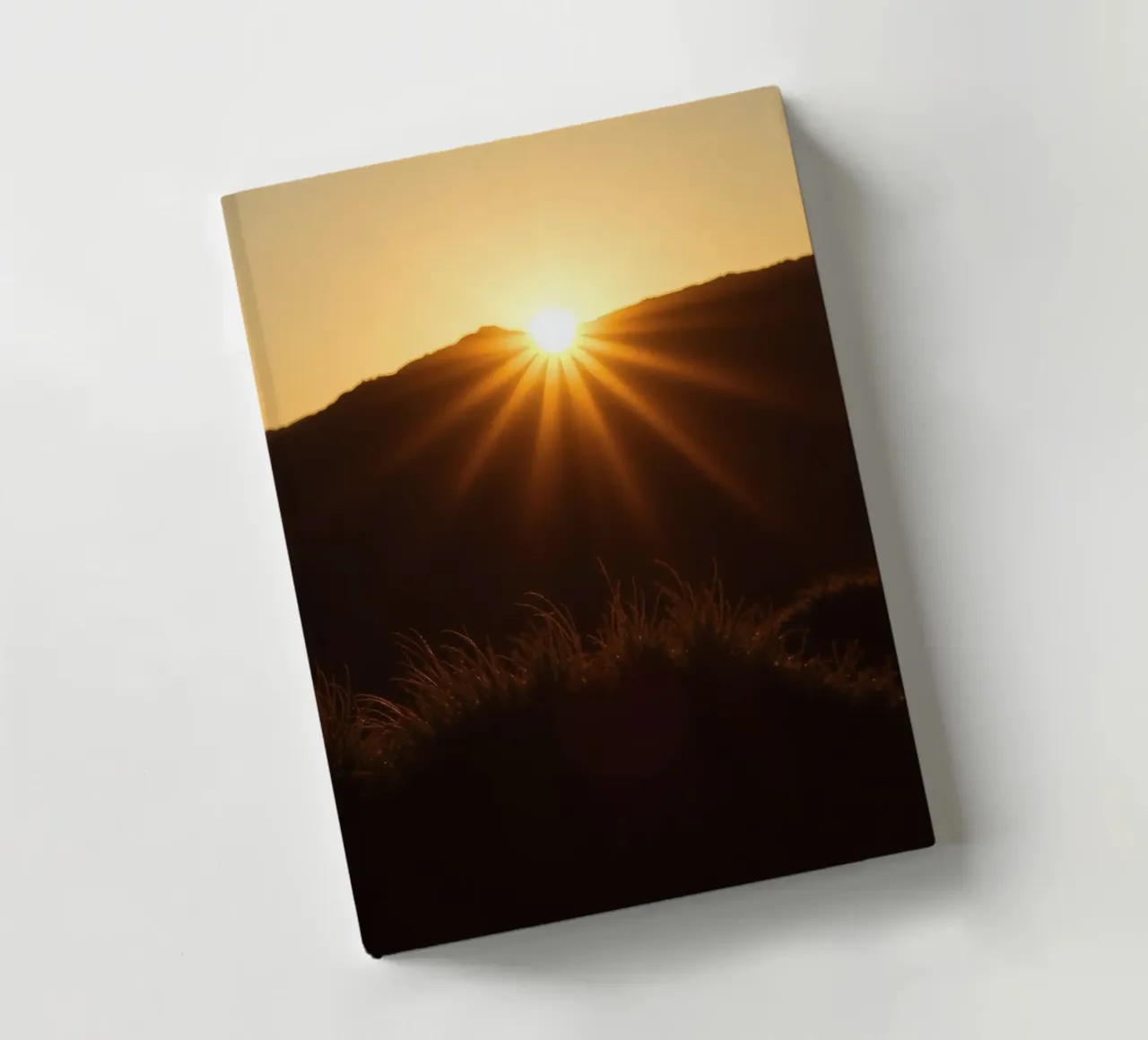 Vibrant sunset casting rays over hillside notebook by DesignDoodle