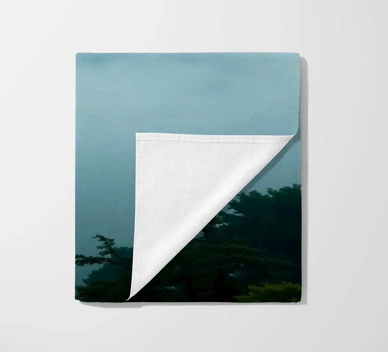 Foggy landscape with trees, creating calming atmosphere beach towel by DesignDoodle