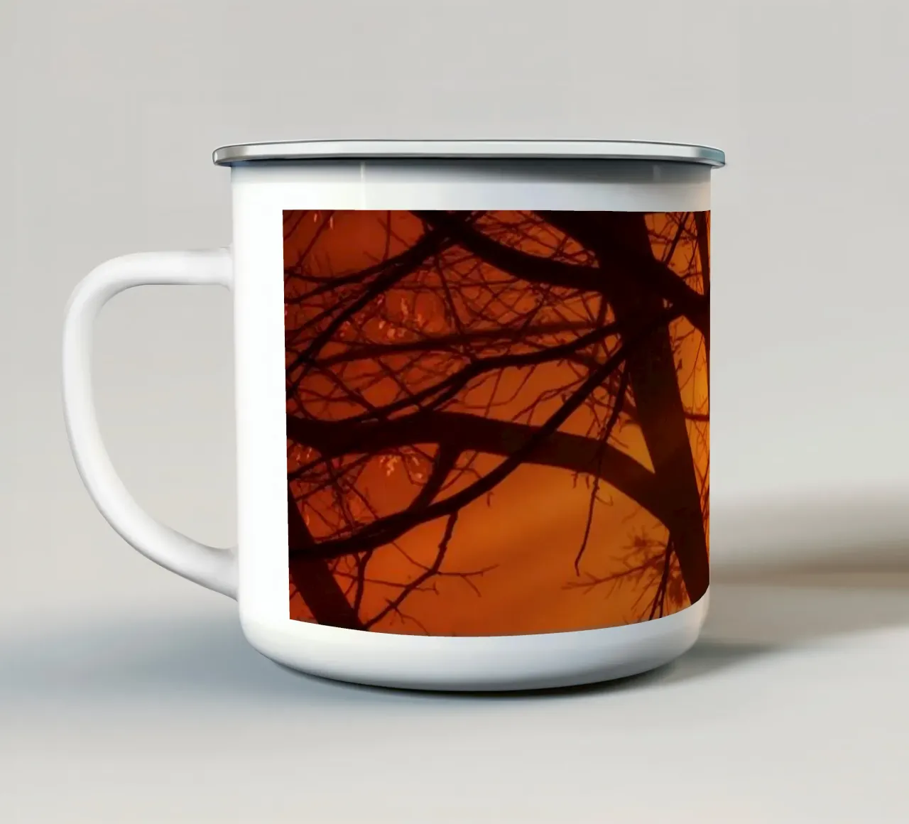silhouette di un albero su uno sfondo arancione vibrante con tazza in smalto da DesignDoodle