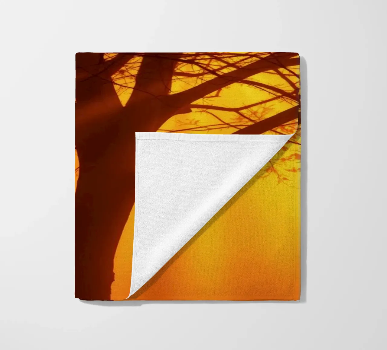 silhouette of a tree against a vibrant orange background wit beach towel by DesignDoodle