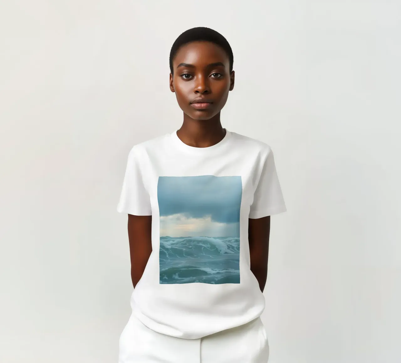 Waves crash against the shore under dark clouds at twilight t-shirt by DesignDoodle