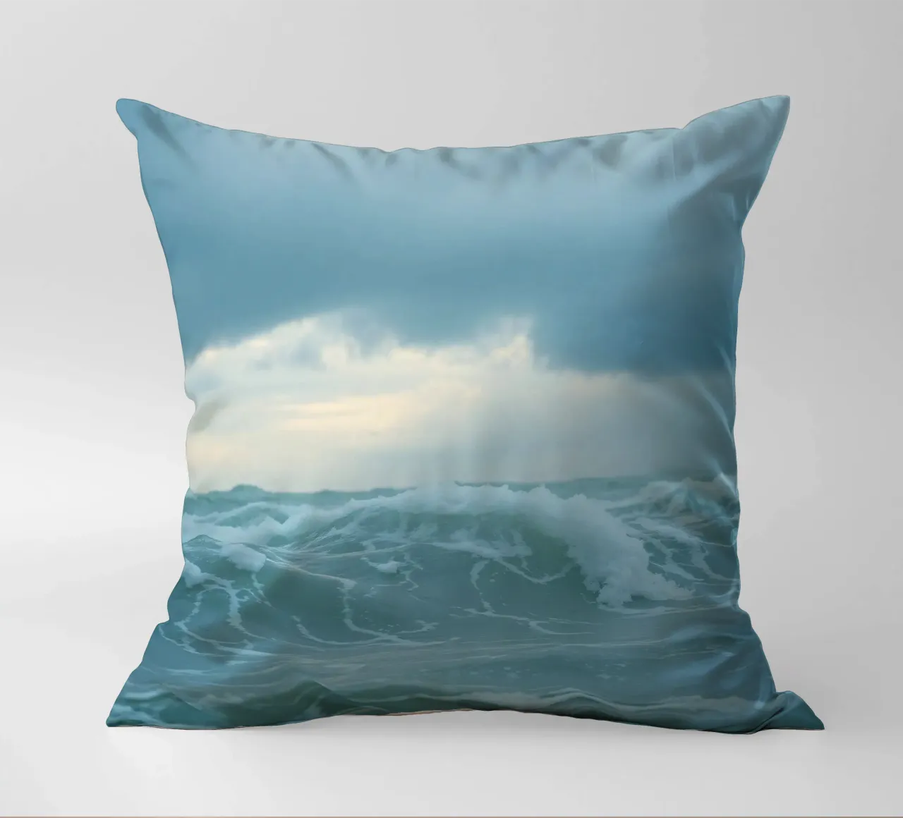Le onde si infrangono sulla riva sotto le nuvole scure del crepuscolo cuscino da DesignDoodle