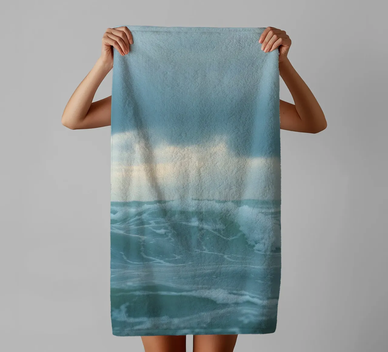 Waves crash against the shore under dark clouds at twilight towel by DesignDoodle