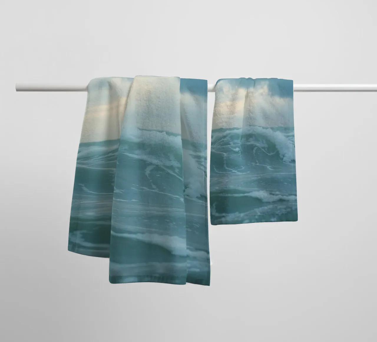 Waves crash against the shore under dark clouds at twilight towel by DesignDoodle