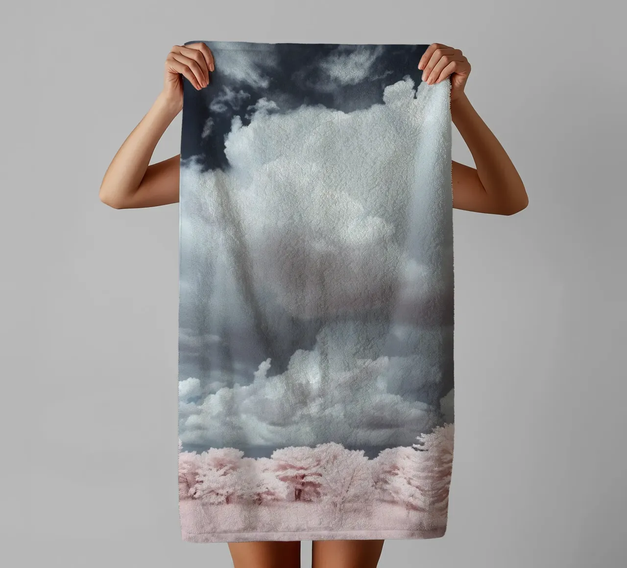 Dramatic clouds hover over pink-tinted trees in an enchantin towel by DesignDoodle