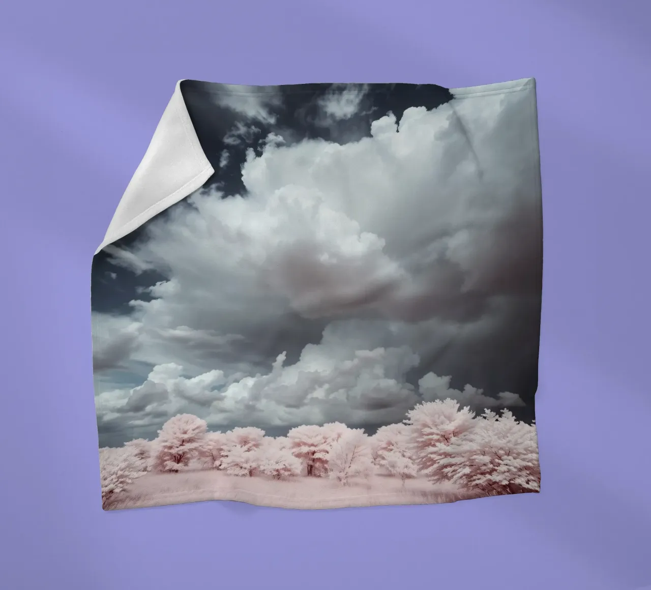Dramatic clouds hover over pink-tinted trees in an enchantin fleece blanket by DesignDoodle