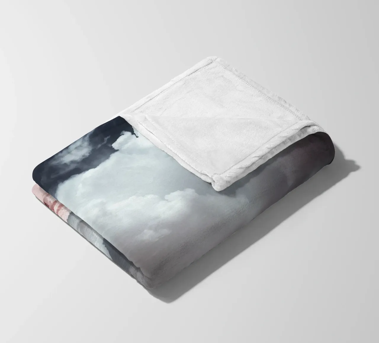 Dramatic clouds hover over pink-tinted trees in an enchantin fleece blanket by DesignDoodle