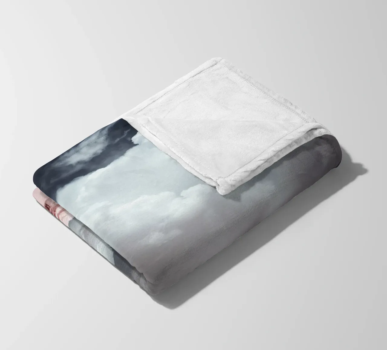 Dramatic clouds hover over pink-tinted trees in an enchantin fleece blanket by DesignDoodle