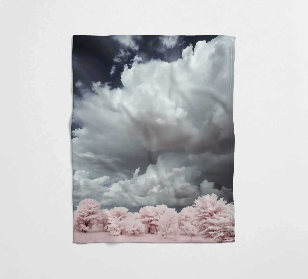 Dramatic clouds hover over pink-tinted trees in an enchantin fleece blanket by DesignDoodle