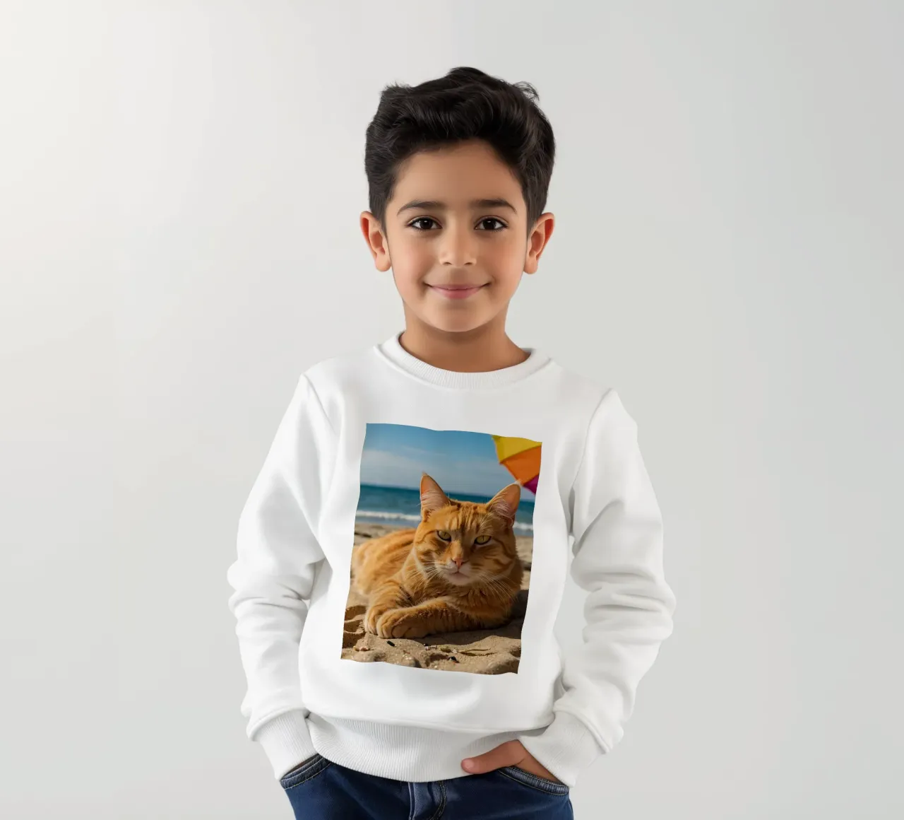 Gatto arancione che si rilassa sulla spiaggia sabbiosa sotto un ombrellone colorato felpa bambino da DesignDoodle