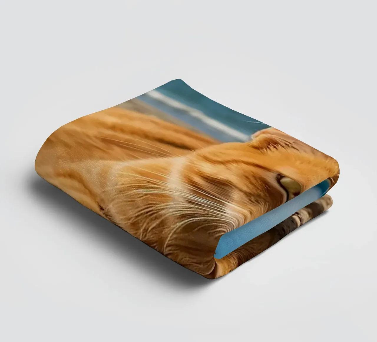 Gatto arancione che si rilassa sulla spiaggia sabbiosa sotto un ombrellone colorato asciugamano da bagno da DesignDoodle