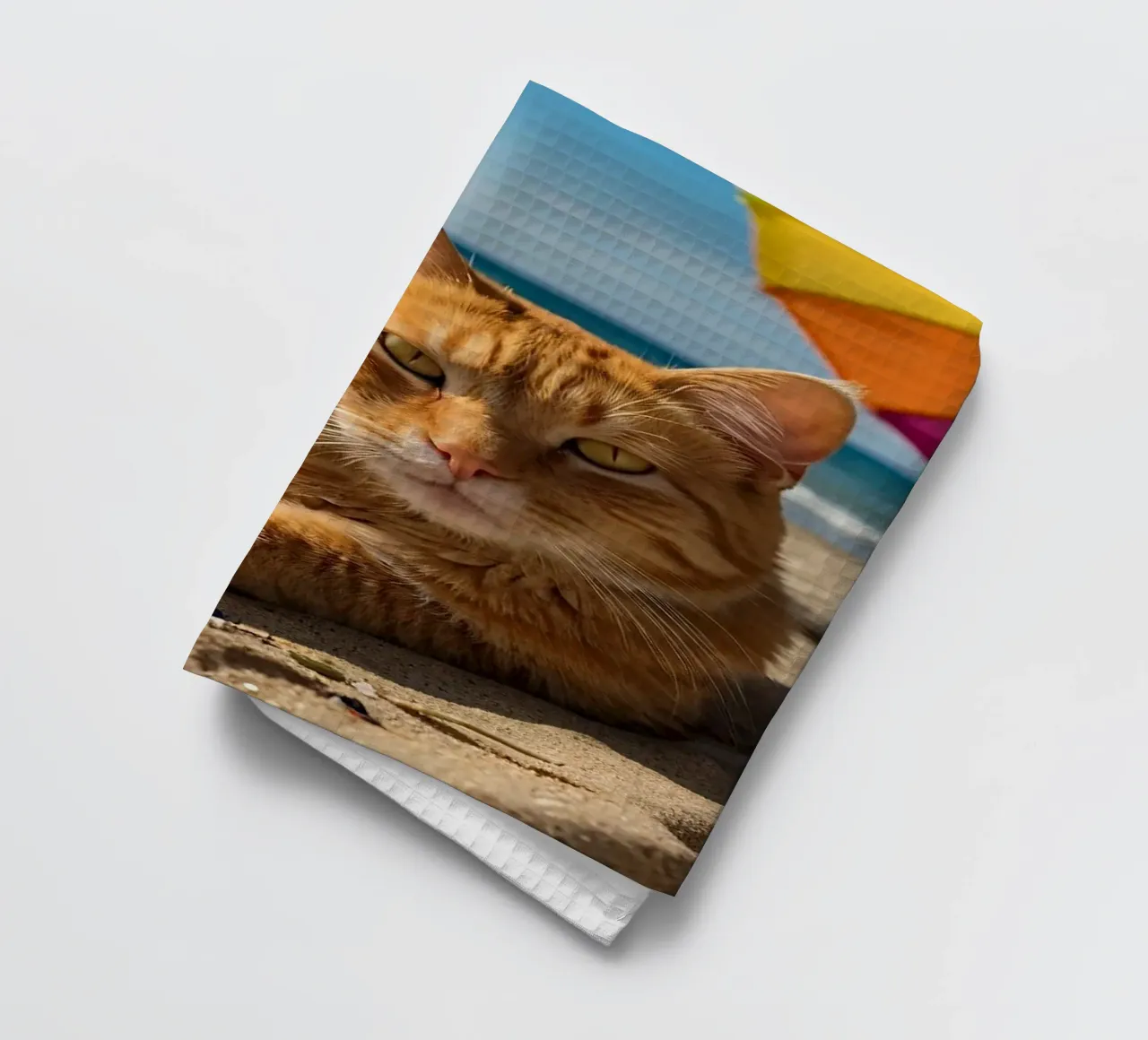 Gatto arancione che si rilassa sulla spiaggia sabbiosa sotto un ombrellone colorato canovaccio da cucina da DesignDoodle
