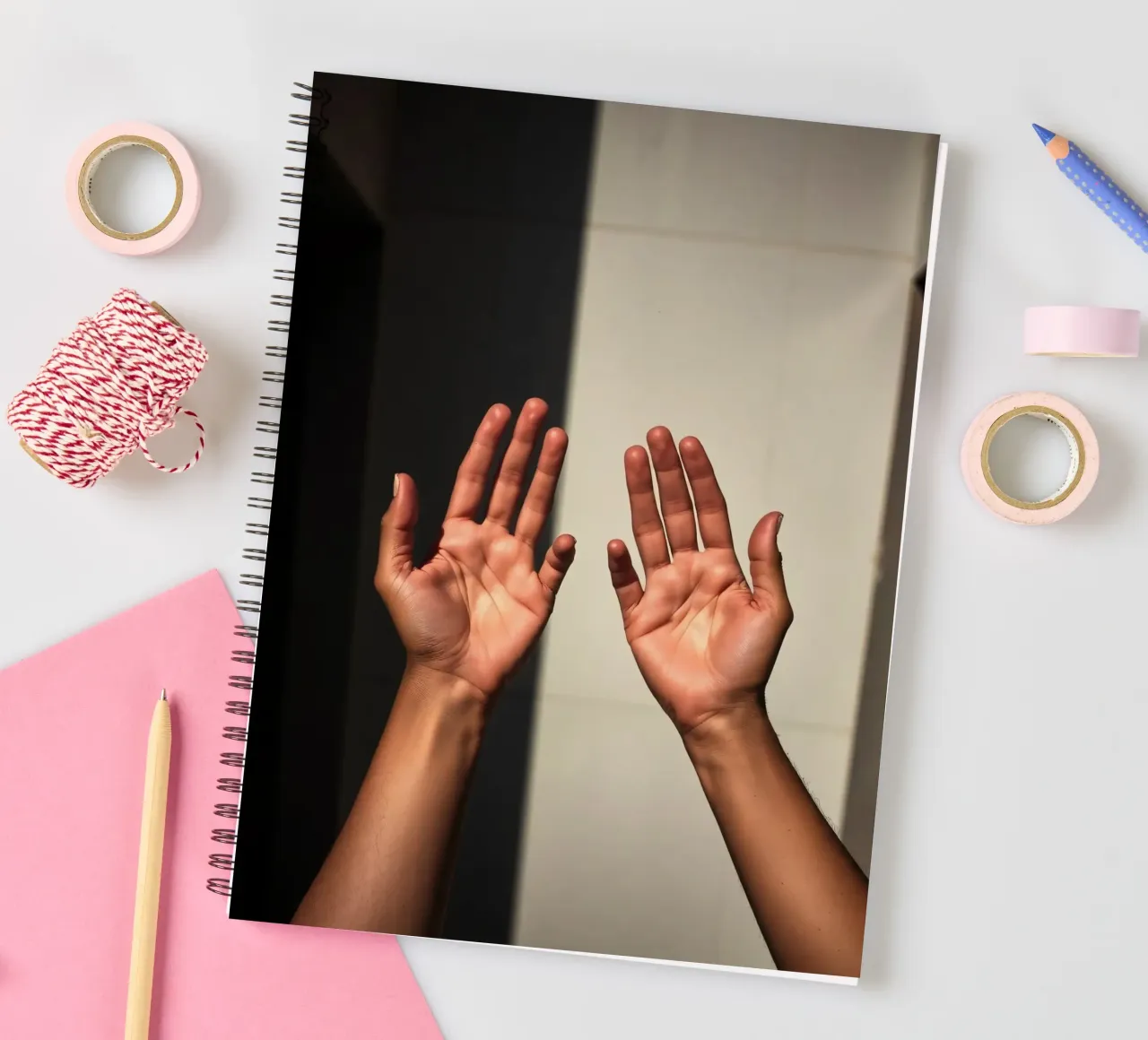 Hands reaching towards light in a minimalist setting spiral notebook by DesignDoodle