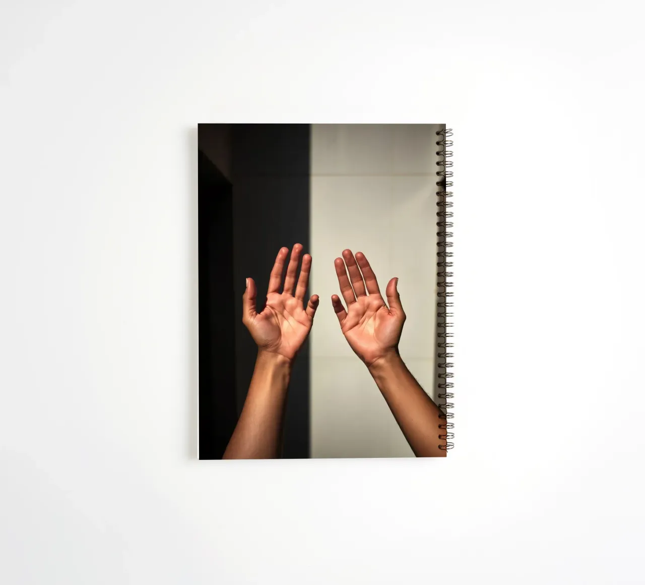 Hands reaching towards light in a minimalist setting spiral notebook by DesignDoodle