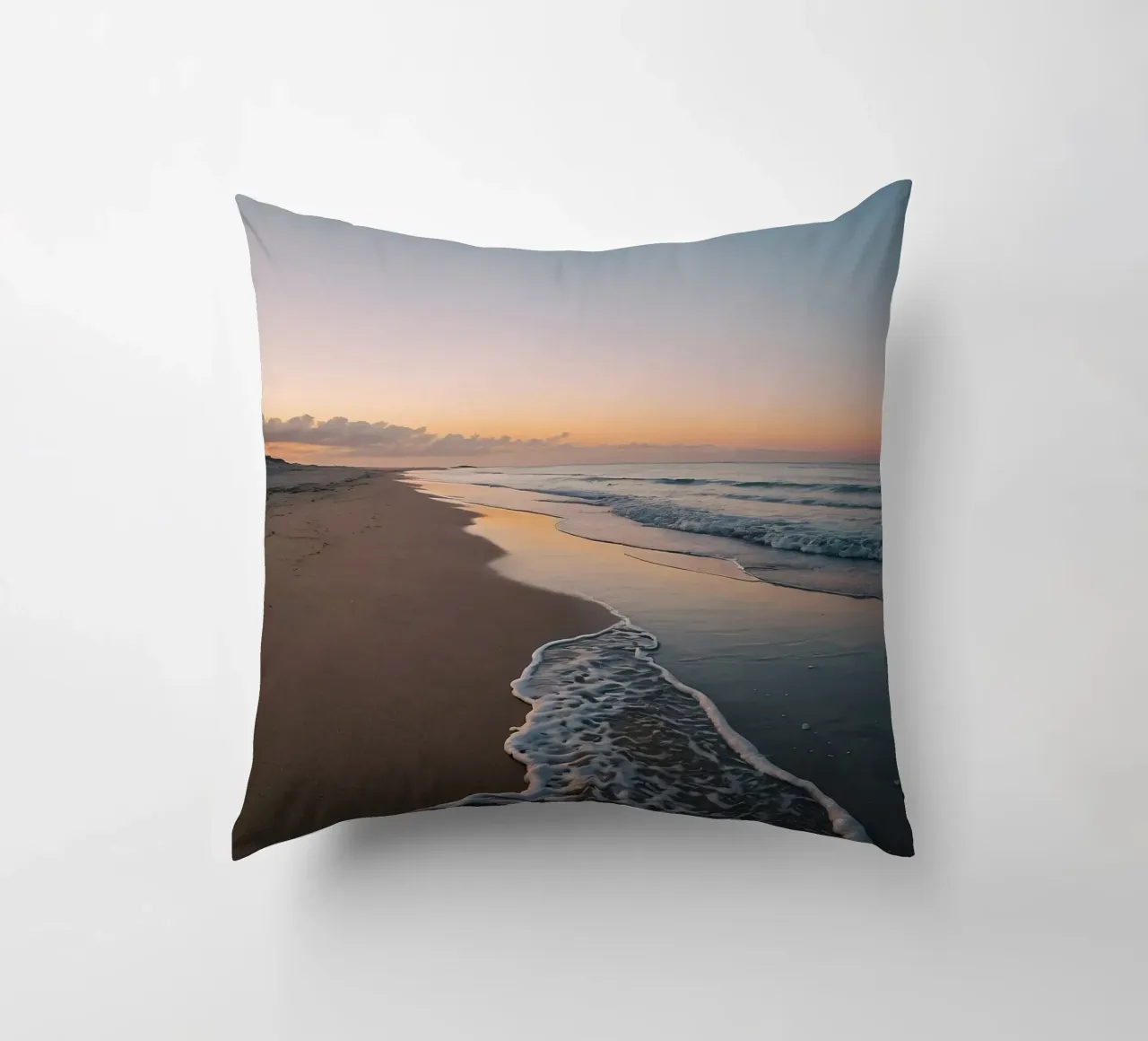 Serene beach at sunset with gentle waves lapping at the shor decorative cushion by DesignDoodle