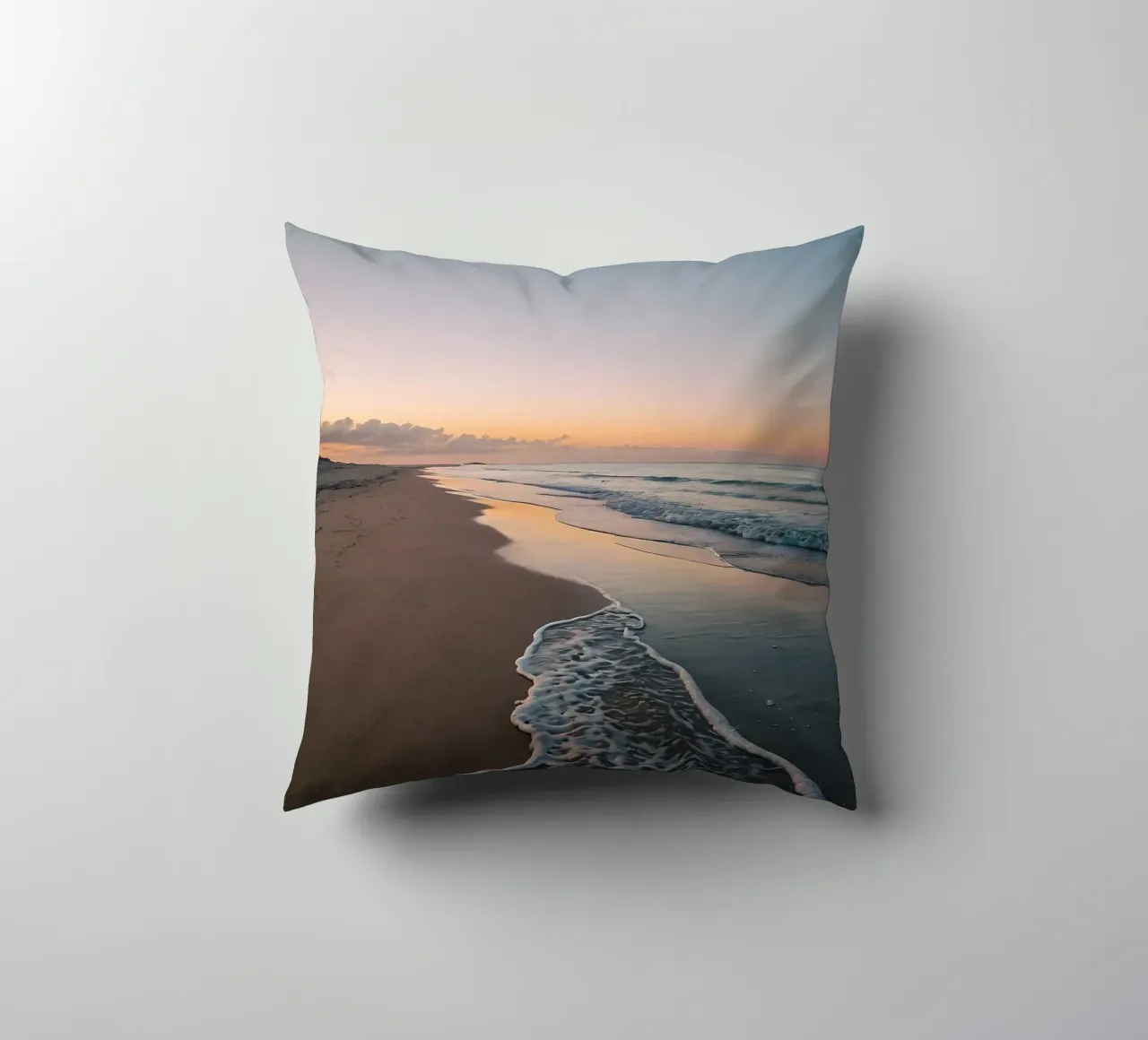 Serene beach at sunset with gentle waves lapping at the shor decorative cushion by DesignDoodle