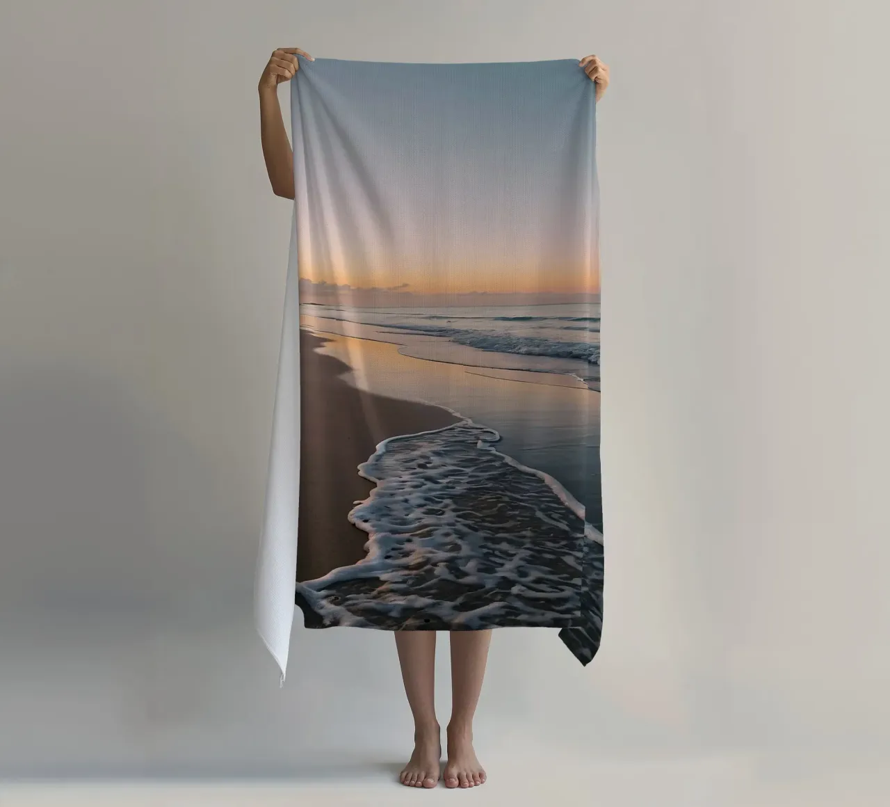 Serene beach at sunset with gentle waves lapping at the shor beach towel by DesignDoodle