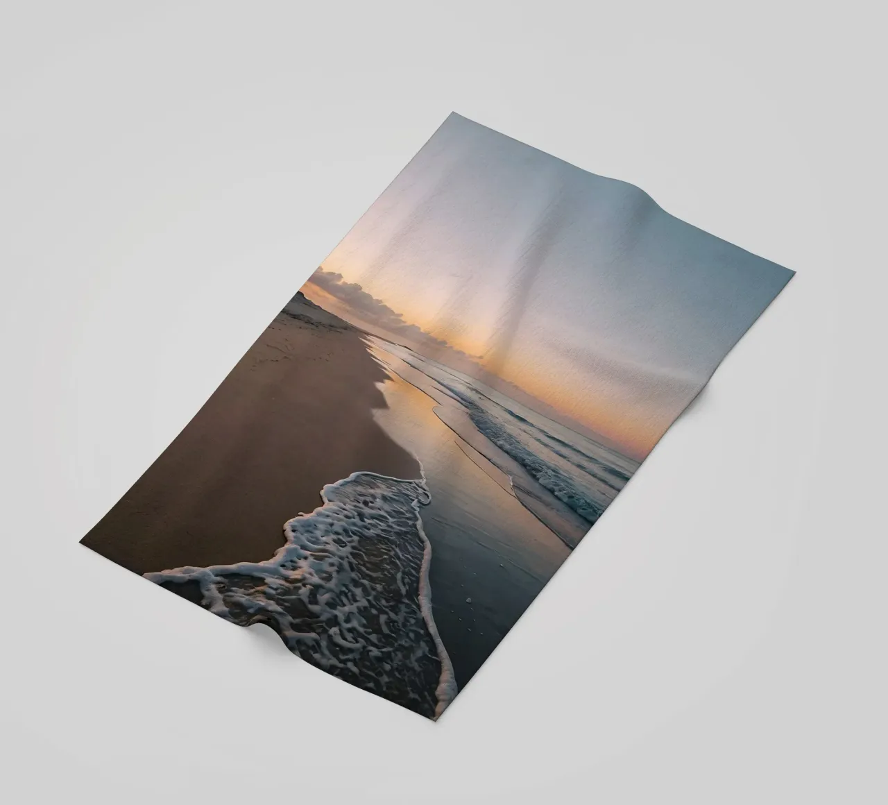 Serene beach at sunset with gentle waves lapping at the shor beach towel by DesignDoodle