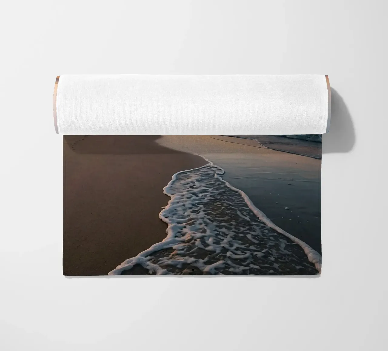 Serene beach at sunset with gentle waves lapping at the shor beach towel by DesignDoodle