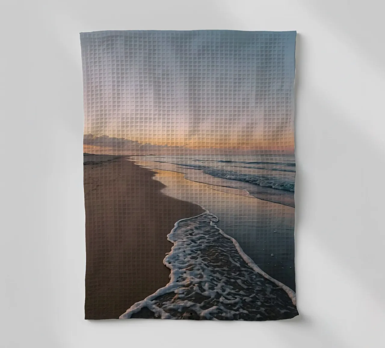 Serene beach at sunset with gentle waves lapping at the shor tea towel by DesignDoodle