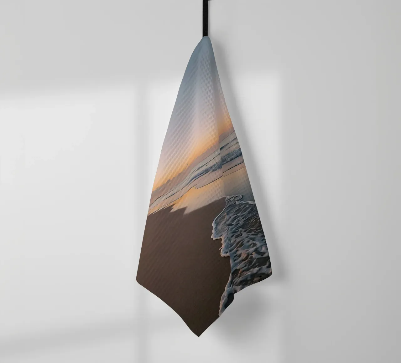 Serene beach at sunset with gentle waves lapping at the shor tea towel by DesignDoodle