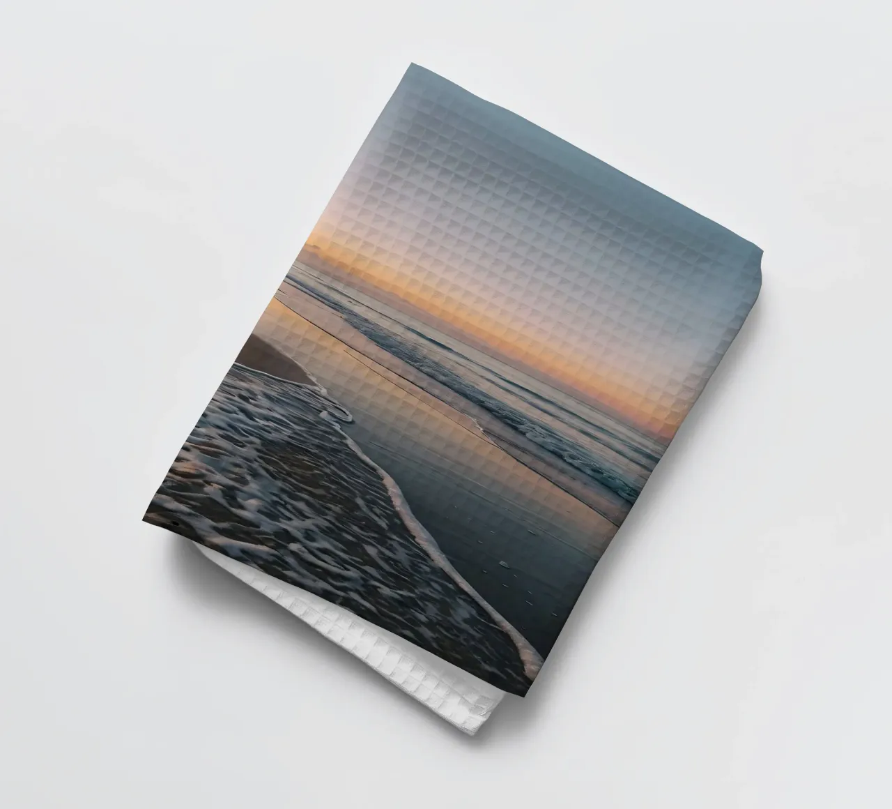 Serene beach at sunset with gentle waves lapping at the shor tea towel by DesignDoodle