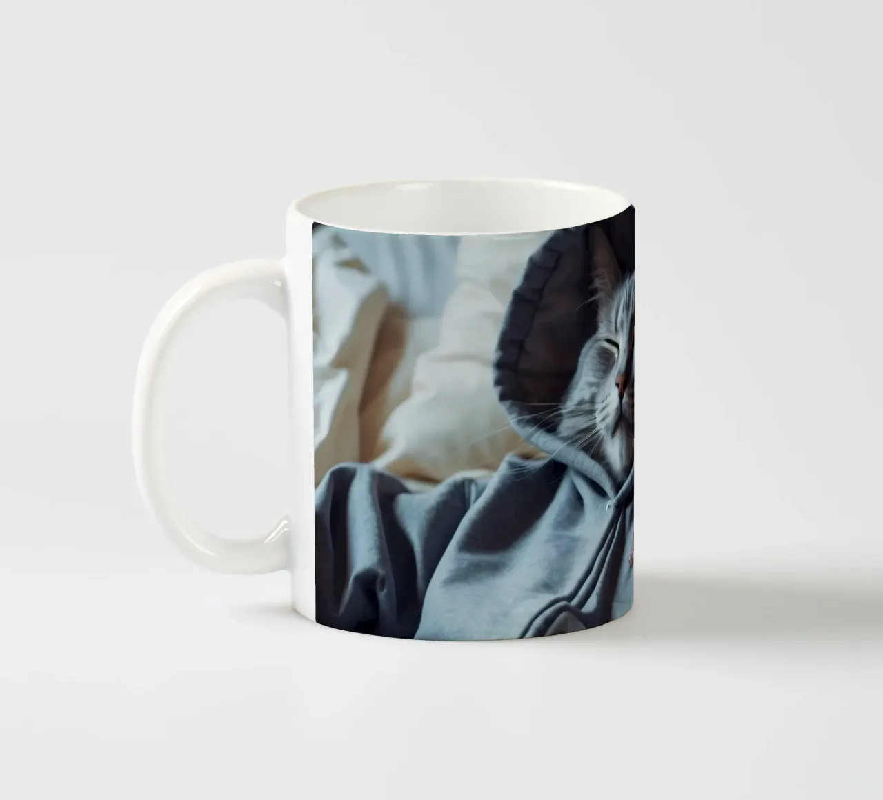 Gatto che riposa comodamente in felpa su un morbido cuscino tazza in ceramica da DesignDoodle