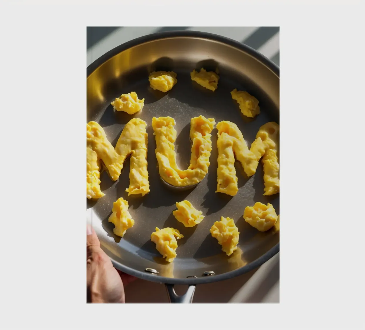 Celebrating Mum with scrambled eggs shaped into letters in a notebook by DesignDoodle