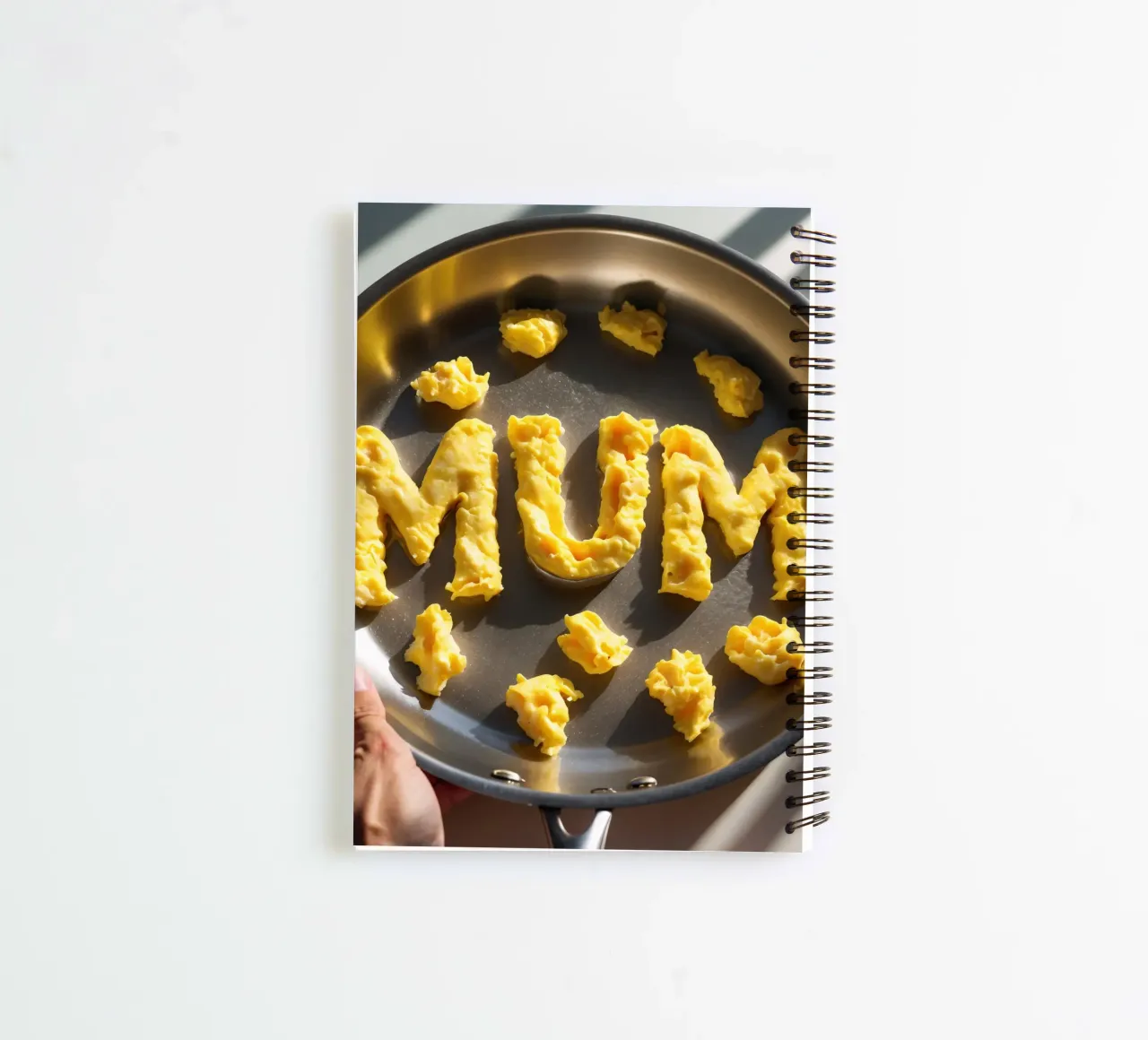 Celebrating Mum with scrambled eggs shaped into letters in a spiral notebook by DesignDoodle