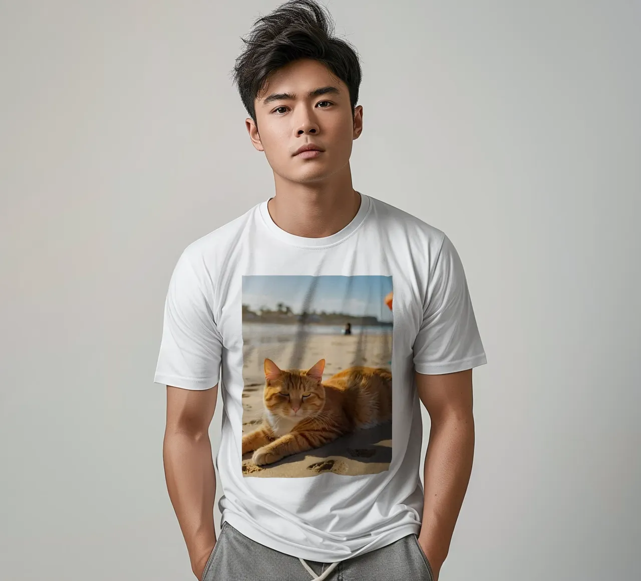 Gatto arancione che si sdraia su una spiaggia assolata con un ombrello t-shirt da DesignDoodle