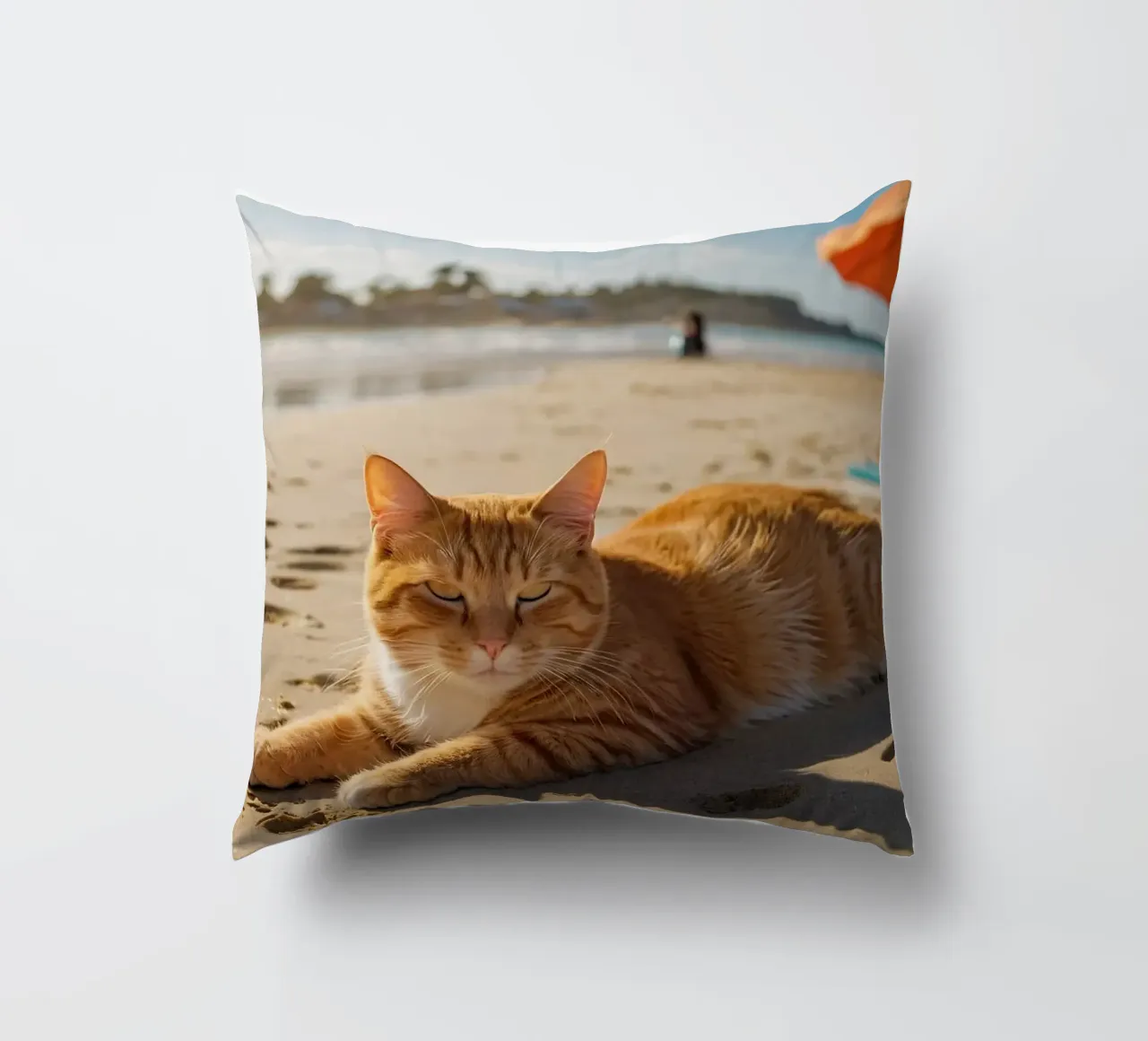 Gatto arancione che si sdraia su una spiaggia assolata con un ombrello cuscino da DesignDoodle