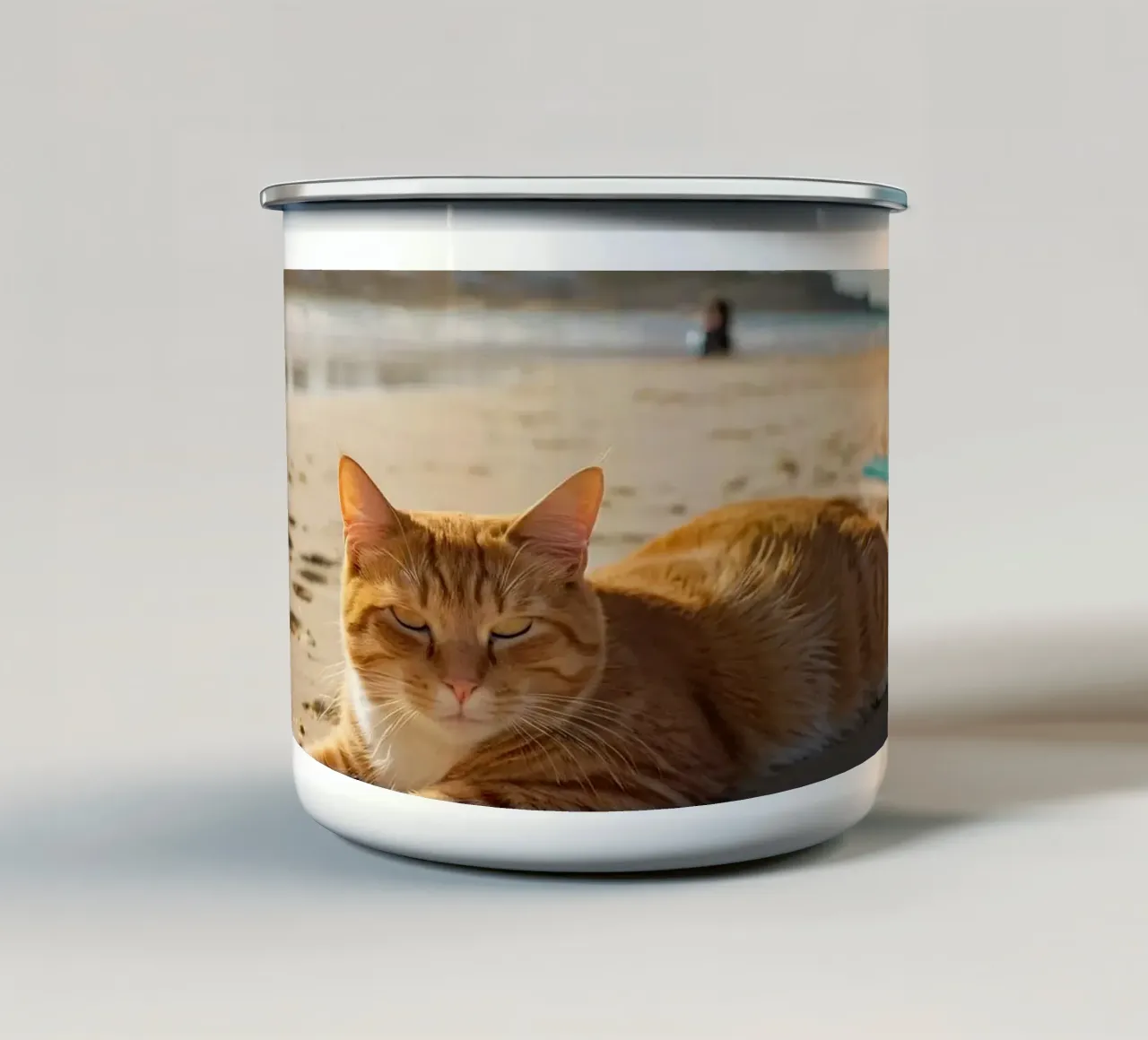 Gatto arancione che si sdraia su una spiaggia assolata con un ombrello tazza in smalto da DesignDoodle