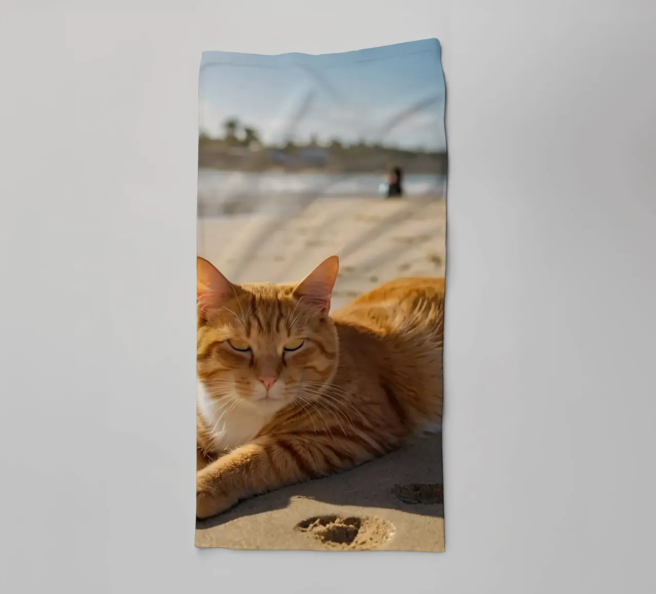 Gatto arancione che si sdraia su una spiaggia assolata con un ombrello asciugamano da bagno da DesignDoodle