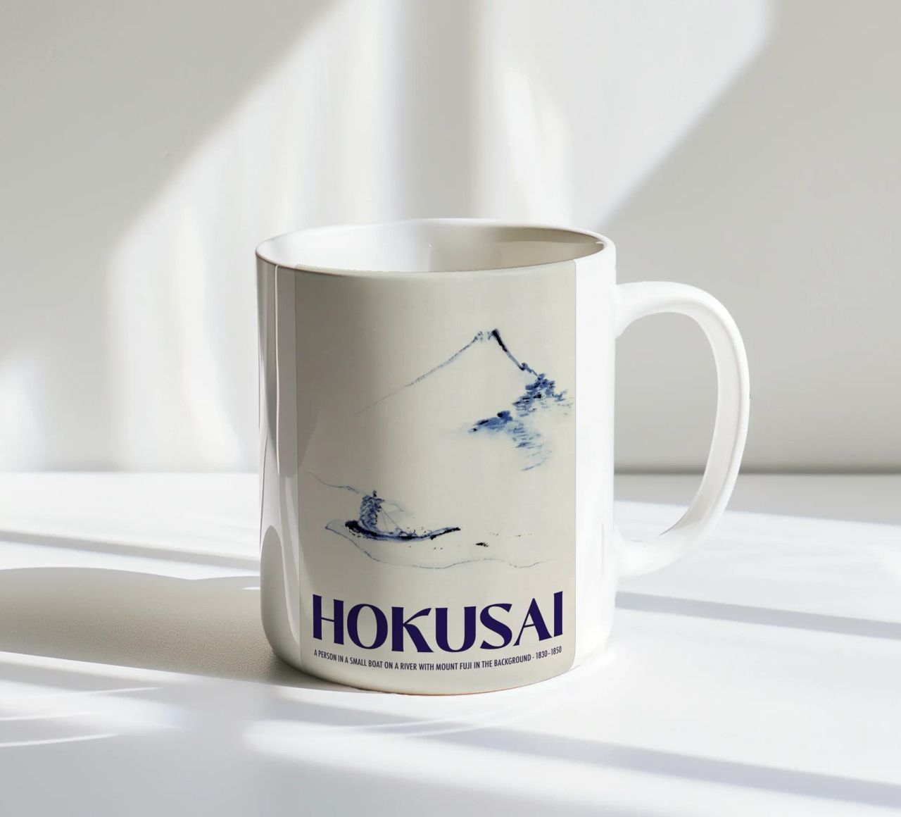 Hokusai - A Person in a Small Boat on a River with Mount Fuji in the Background III mug en céramique de Vintage by JUNIQE