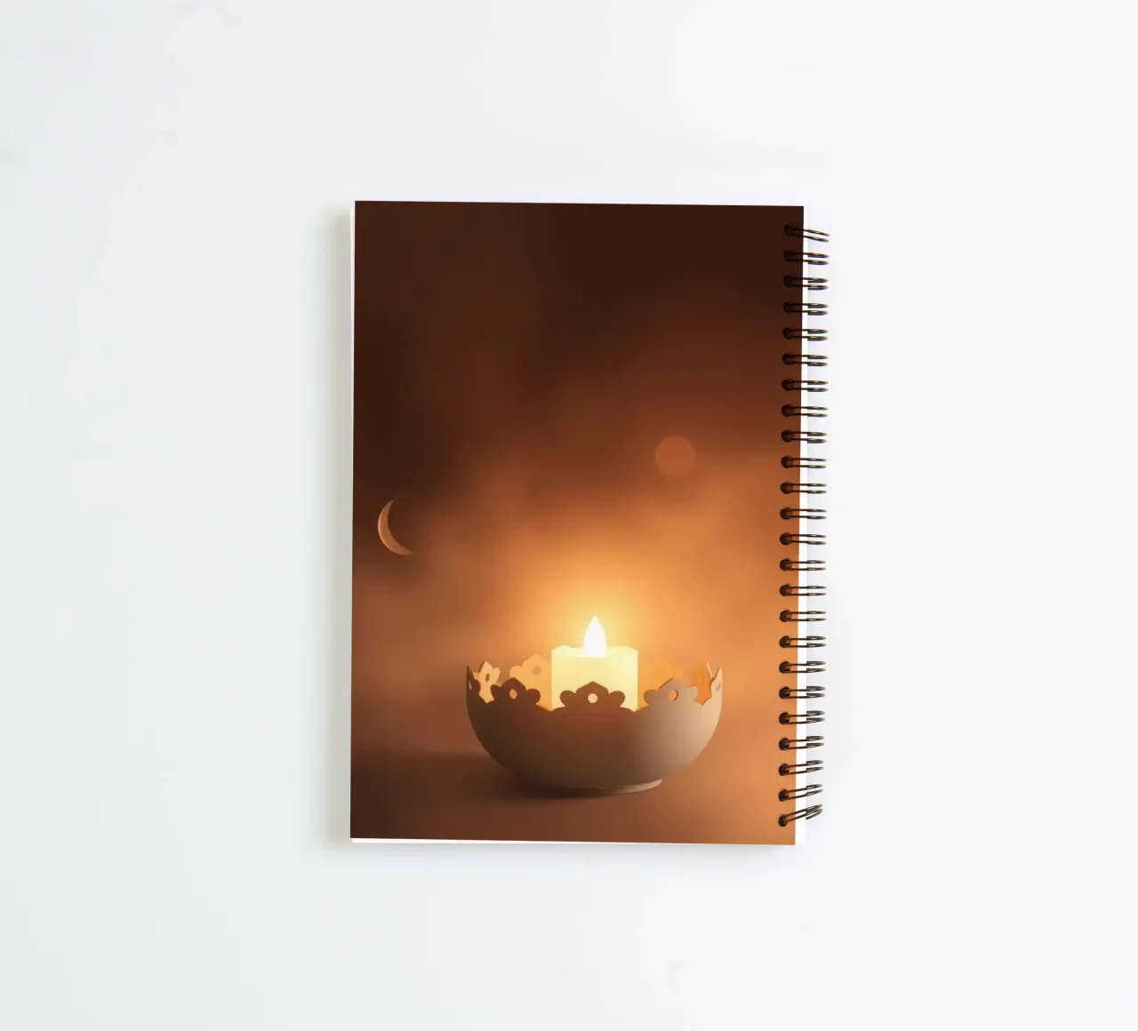 Softly glowing candle in an ornate holder surrounded by wisp spiral notebook by DesignDoodle