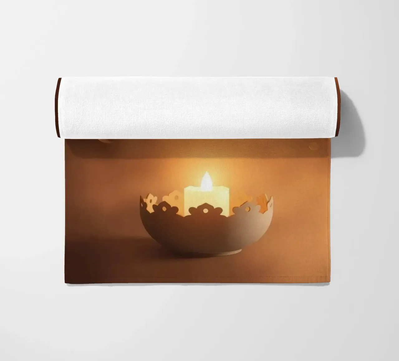 Candela a luce soffusa in un supporto ornato, circondata da un ciuffo di foglie. telo mare da DesignDoodle