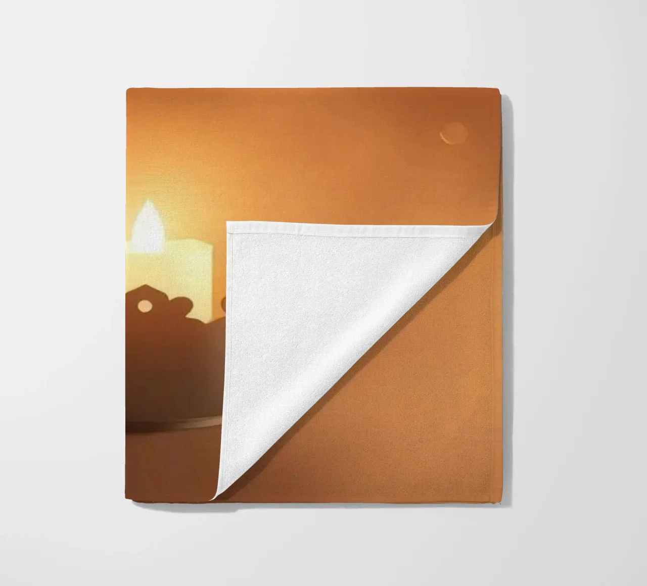 Candela a luce soffusa in un supporto ornato, circondata da un ciuffo di foglie. telo mare da DesignDoodle