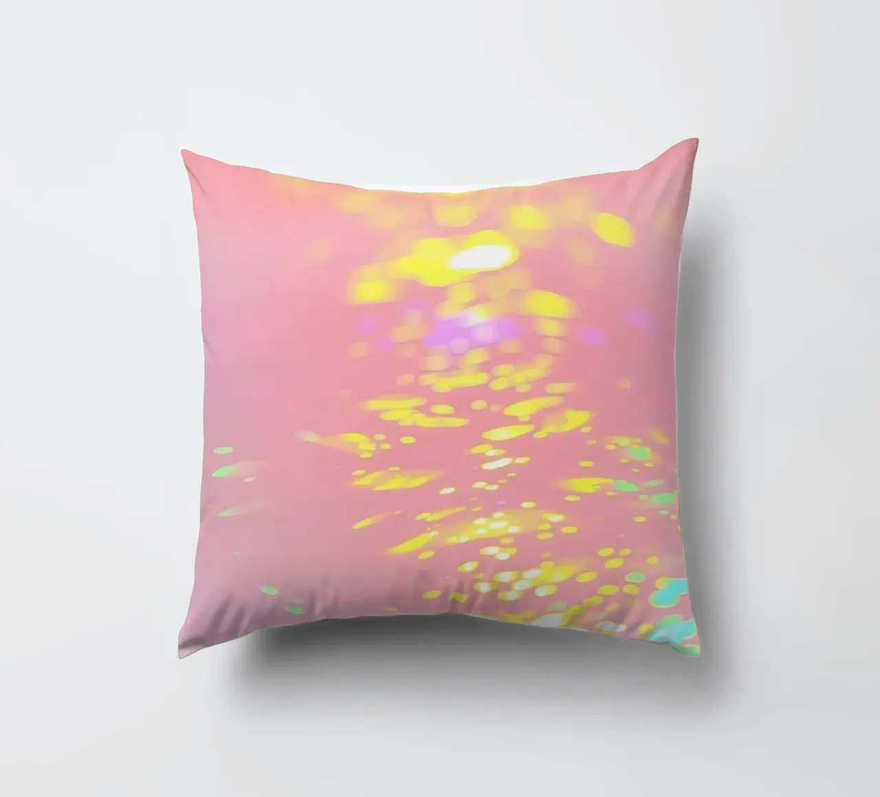 Riflessi scintillanti di luce colorata su un'arte rosa tenue cuscino da DesignDoodle