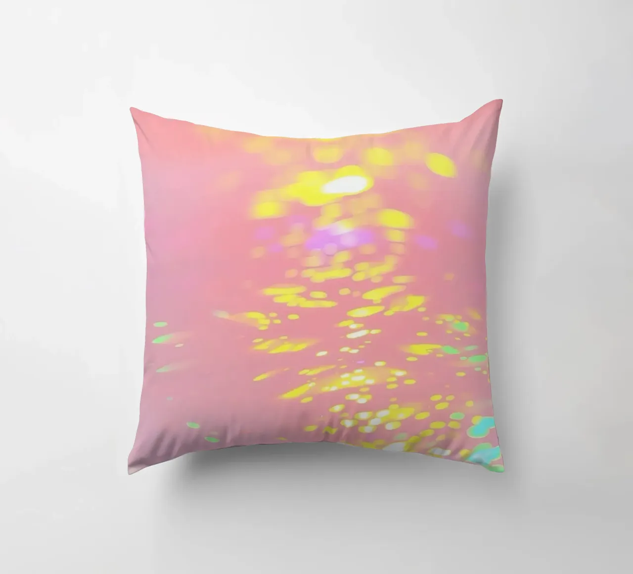 Riflessi scintillanti di luce colorata su un'arte rosa tenue cuscino da DesignDoodle