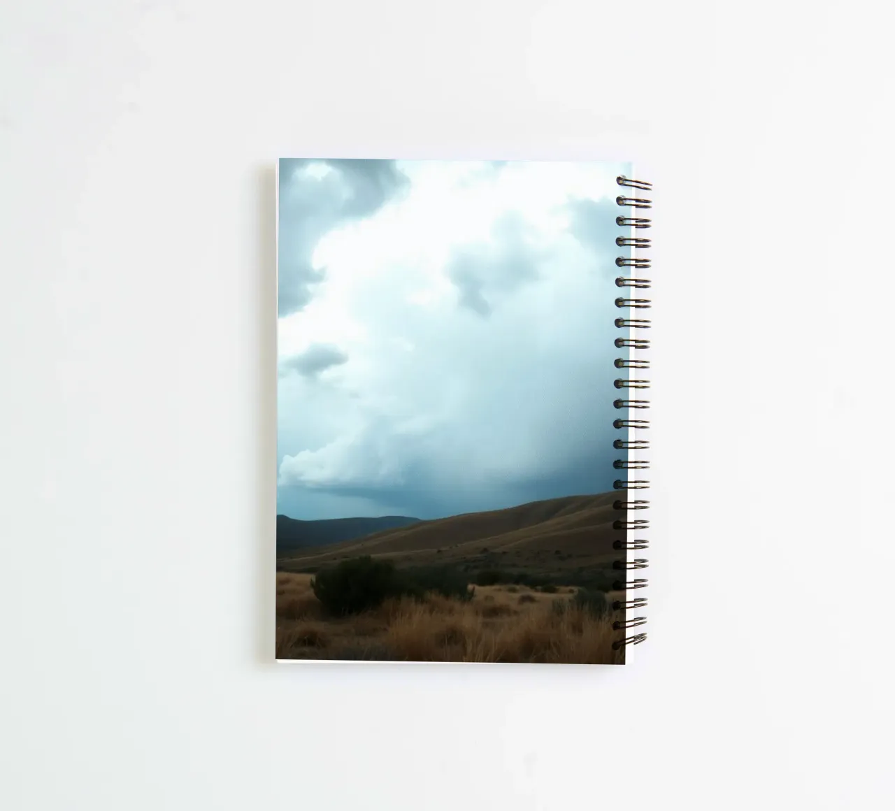 Dark storm clouds gather over a vast landscape spiral notebook by DesignDoodle
