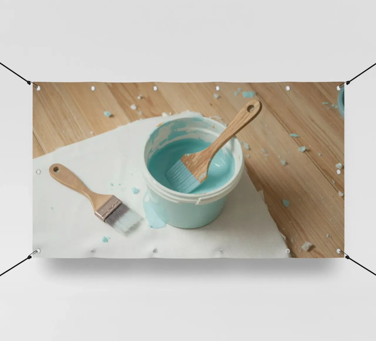 Il pennello di legno è appoggiato in un barattolo di vernice blu accanto a un pennello piccolo. telo in pvc da DesignDoodle