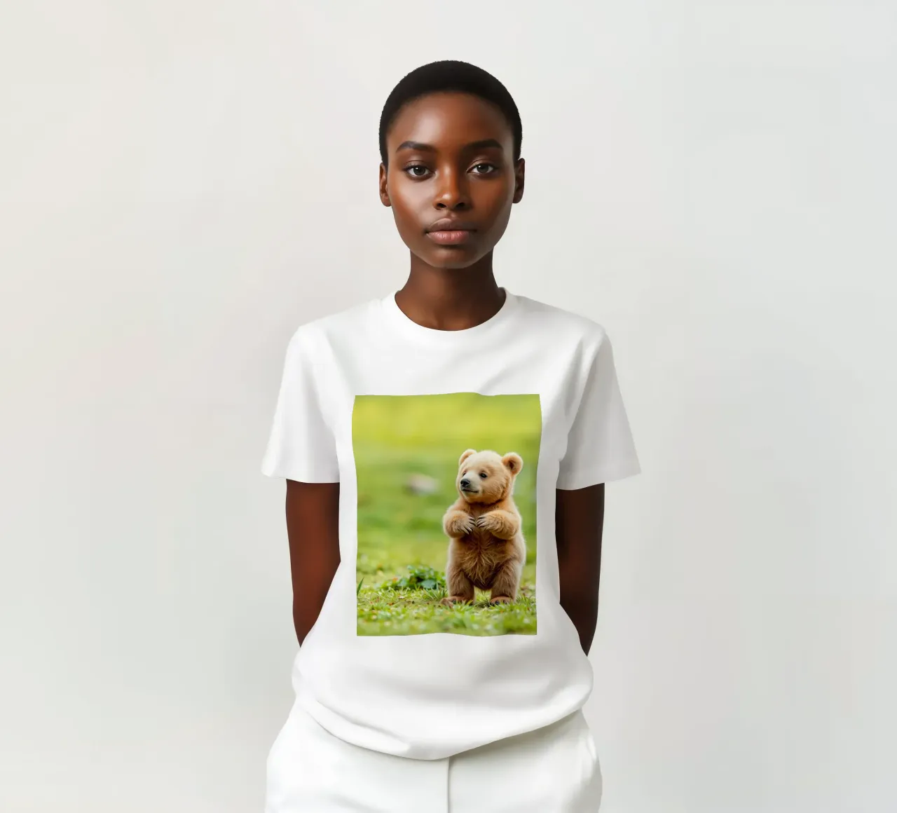 Un tenero cucciolo di orso bruno si regge su due zampe in un campo verde e rigoglioso t-shirt da DesignDoodle