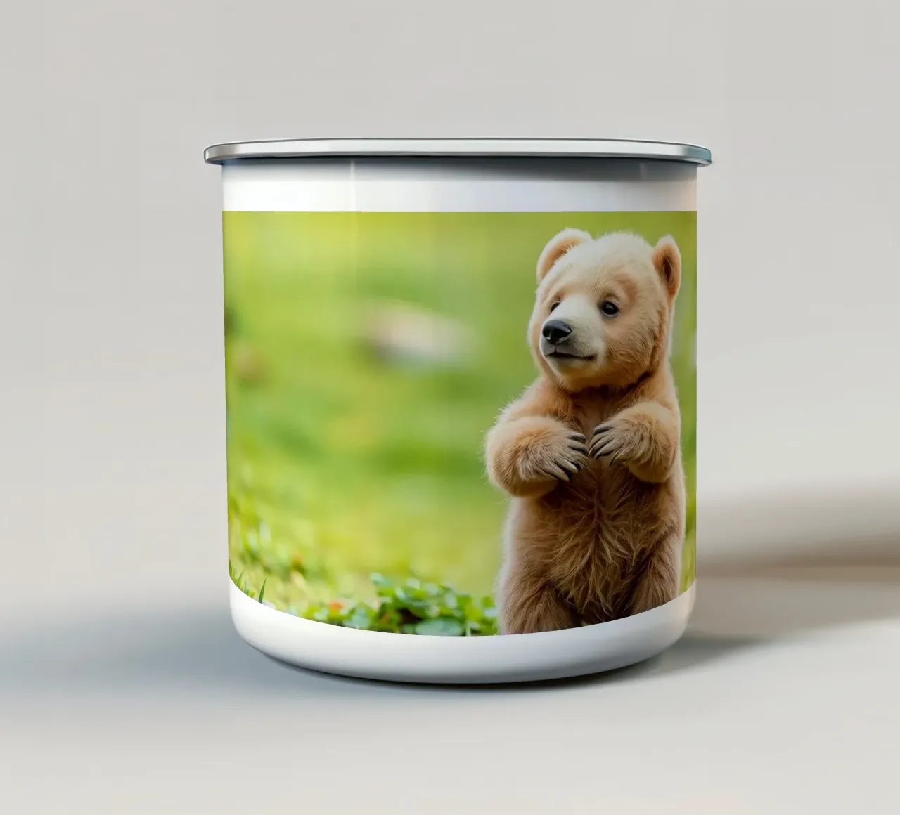 Un tenero cucciolo di orso bruno si regge su due zampe in un campo verde e rigoglioso tazza in smalto da DesignDoodle